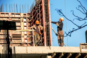 Two construction workers adjusting the formwork on a building site